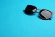 © New Africa - Stylish sunglasses on blue background, space for text. Fashionable accessory