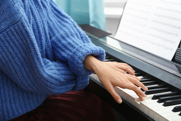 Poster - Young woman playing piano at home, closeup