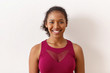 © Anatoliy Karlyuk - Close up shot of cheerful energetic young dark skinned woman in trendy sports top posing isolated with voluminous hair gathered looking at camera with broad smile, showing her white perfect teeth