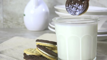 Poster - Dunking a duplex vanilla cream sandwich cookie into milk, slow motion