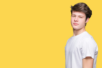 Young handsome man wearing casual white t-shirt over isolated background with serious expression on face. Simple and natural looking at the camera.