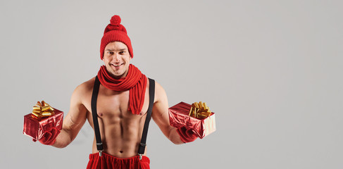 Athletic man with gifts smiling at christmas.