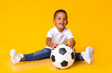 Cute Black Baby Boy Sitting On Floor With Soccer Ball