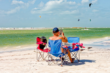 Person sitting in beach chair taking photo