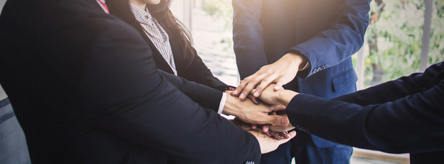 Wall Mural - Business partner teamwork, group of people put hand up together to make power in office