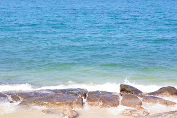 the rocks are at the coast and there are sea waves