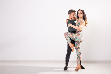 Young couple dancing latin dance bachata, merengue, salsa, kizomba. Two elegance pose over white background with copy space