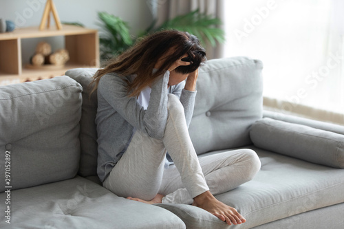 Fotografía Stressful young mixed race woman holding head in hands.