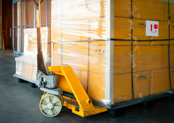 Hand pallet truck with stacked package boxes on pallet