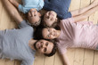© fizkes - Happy parents with little children lying on floor top view