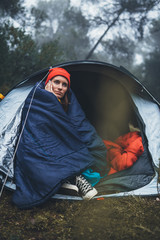 Wall Mural - tourist traveler ralaxing in camp tent on background foggy rain forest, lonely hiker woman enjoy mist nature trip, green trekking tourism, rest vacation concept camping holiday