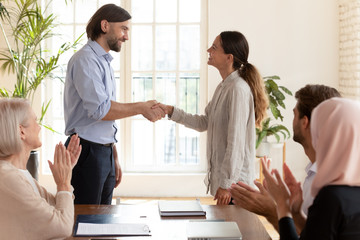 Wall Mural - boss shaking hand of female employee intern congratulating with promotion