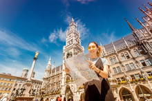 Happy Asian Woman With Map Searching For Sights And Interesting Places In Munich City With Town Hall At The Background.