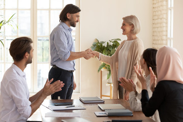 Wall Mural - happy old middle aged female employee get promotion team appreciation