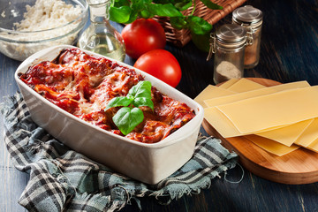 Wall Mural - Hot tasty lasagna with spinach in ceramic casserole dish