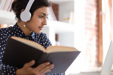 Indian woman prepare essay using textbook and internet online website