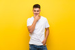 © luismolinero - Young handsome man over isolated yellow background thinking