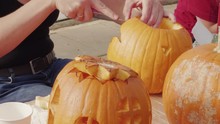 Woman Hands Carving Orange Pumpkin For Halloween Celebration, Vegetable With Carved Haunted House, Castle, Windows, 3 Shots. Person Cutting Pumpkins By Knife To Create Lantern, Drying Lid Hole By Wipe
