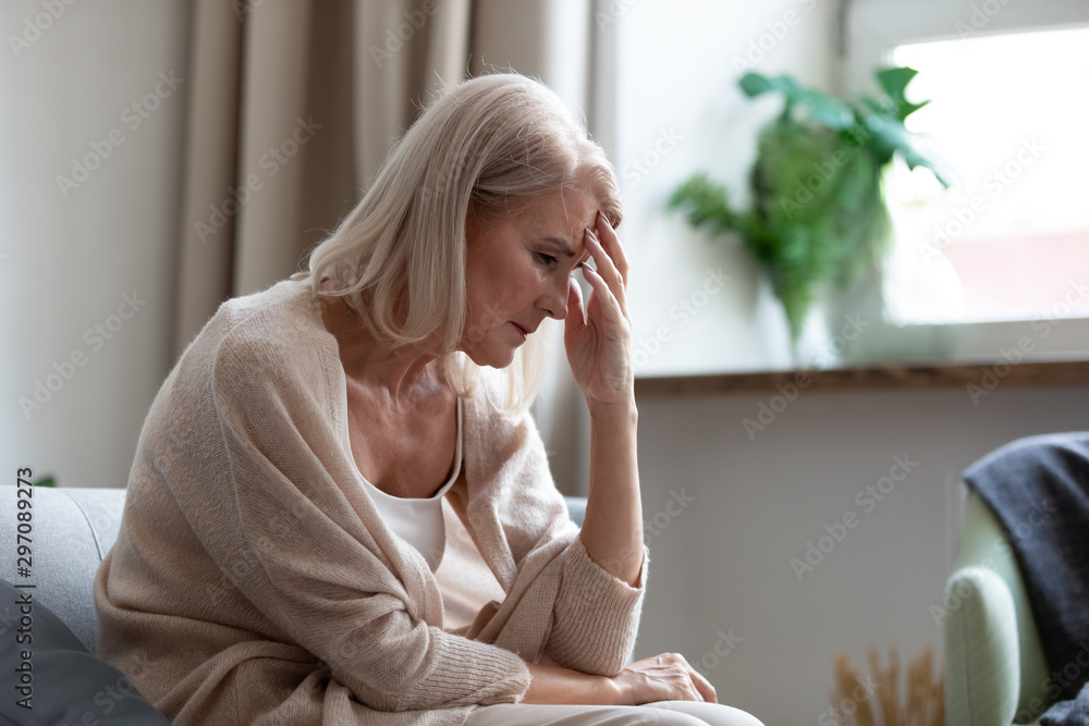 Sad mature woman sitting alone at home feeling headache depression - obrazy, fototapety, plakaty 