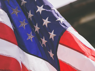 American flag waving in the wind with blue sky and is a symbol of peace.