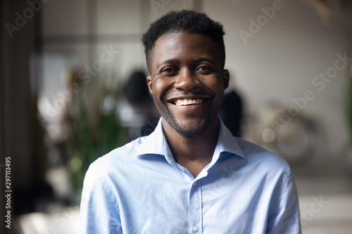 Fotomural Confident smiling young african businessman looking at camera in office