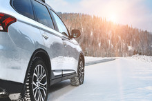 Modern Suv Four Wheel Drive Car Stay On Roadside Of Winter Road. Family Trip To Ski Resort Concept. Winter Or Spring Holidays Adventure. Car On Winter Snowy Road In Mountains In Sunny Day.