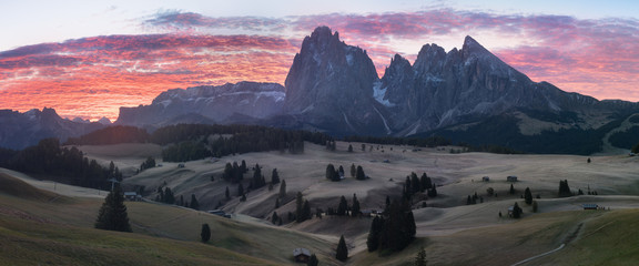 Alpe di Siusi - Seiser Alm with Sassolungo - Langkofel mountain group in background at sunset. Colorful autumn landscape and wooden chalets in Dolomites, Trentino Alto Adige, Italy, Europe Dolomiti