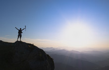 Man At The Top Celebrating Success With The Sun In The Background