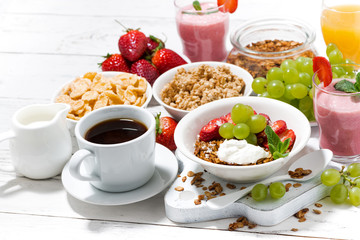 delicious and healthy breakfast with fruits, granola and milkshake on white background