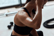 © alfa27 - Fit woman with strong muscles after active training in fitness gym. closeup Sweat skin. Kettlebells behind