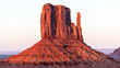 Panoramic view of mittens butte mesa with vibrant colorful red orange rock color on horizon in Monument Valley canyons during sunset in Arizona