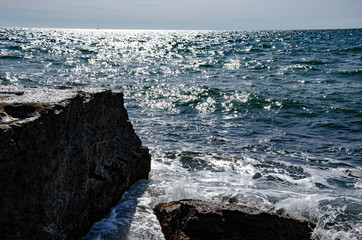 Traveling to the sea, a wave rolls over stones.