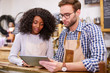 © marvent - Two baristas working on a tablet behind their cafe counter
