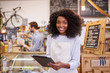 © marvent - Smiling African America barista using a tablet in her cafe