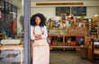© marvent - Friendly African American barista standing at a cafe door