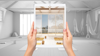 Hands holding tablet showing empty yoga studio, mats and accessories, total blank project background, augmented reality concept, application to simulate interior design products