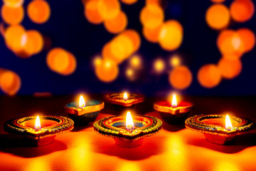 Wall Mural - Indian festival Diwali, Diya oil lamps lit on colorful rangoli. Hindu traditional. Happy Deepavali. Copy space for text.