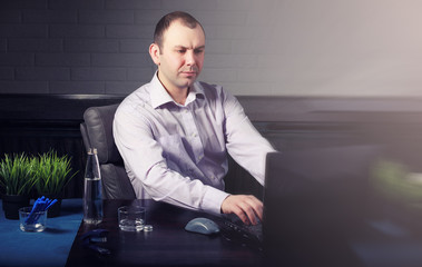 man at table and working on laptop