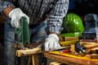 © francescomou - Adult carpenter craftsman wears protective leather gloves, with electric saw working on cutting a wooden table. Construction industry, housework do it yourself. Stock photography.
