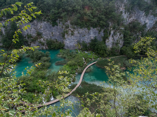 Wall Mural - Croatia, august 2019: Tourists on the wooden park pathways enjoying the view of emerald lakes, cascades and crystal clear water, Plitvice Lakes National Park