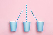 Pink Paper Drinking Cup And Striped Straws On Duotone Pink And Blue Background. Birthday Party Celebration Abstract Fashion Baby Shower Concept. Minimalist Pastel Style.