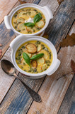 Fototapeta Na sufit - Two servings Autumn cream soup with vegetables, croutons, pumpkin seeds and fresh spinach on a rustic background. Vertical shot