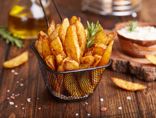 Canvas Print - Potato wedges baked with rosemary. Delicious snack served with sauce. Fast food.