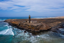 Reflexes On The Water Puddles Of Cliffs And Lighthouse, Jandia Tip In Coast Of Fuerteventura, Canary Islands. Aerial Drone Shot, October 2019