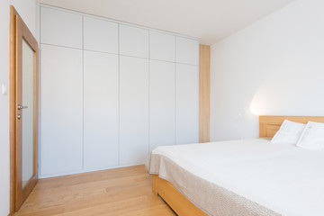 White wooden closet in bedroom of contemporary apartment