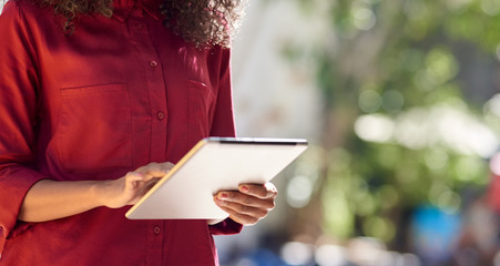 Wall Mural - African American woman using a digital tablet in the city