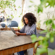 © marvent - Young woman sitting sitting outside using a digital tablet