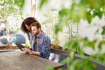 Diverse young couple using a tablet together on their patio