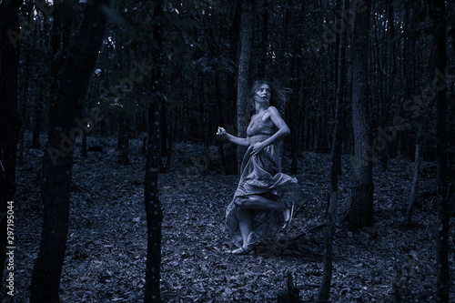 Fotografía Scared girl running through forest