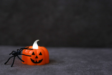 Wall Mural - Orange pumpkin lantern with black spider on brown background. Place for text. Halloween concept